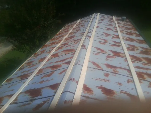 Rusted metal roof panels with new wood purlins before replacement — Storm Damage Roof Repair in Hardwick by Roofing Brothers