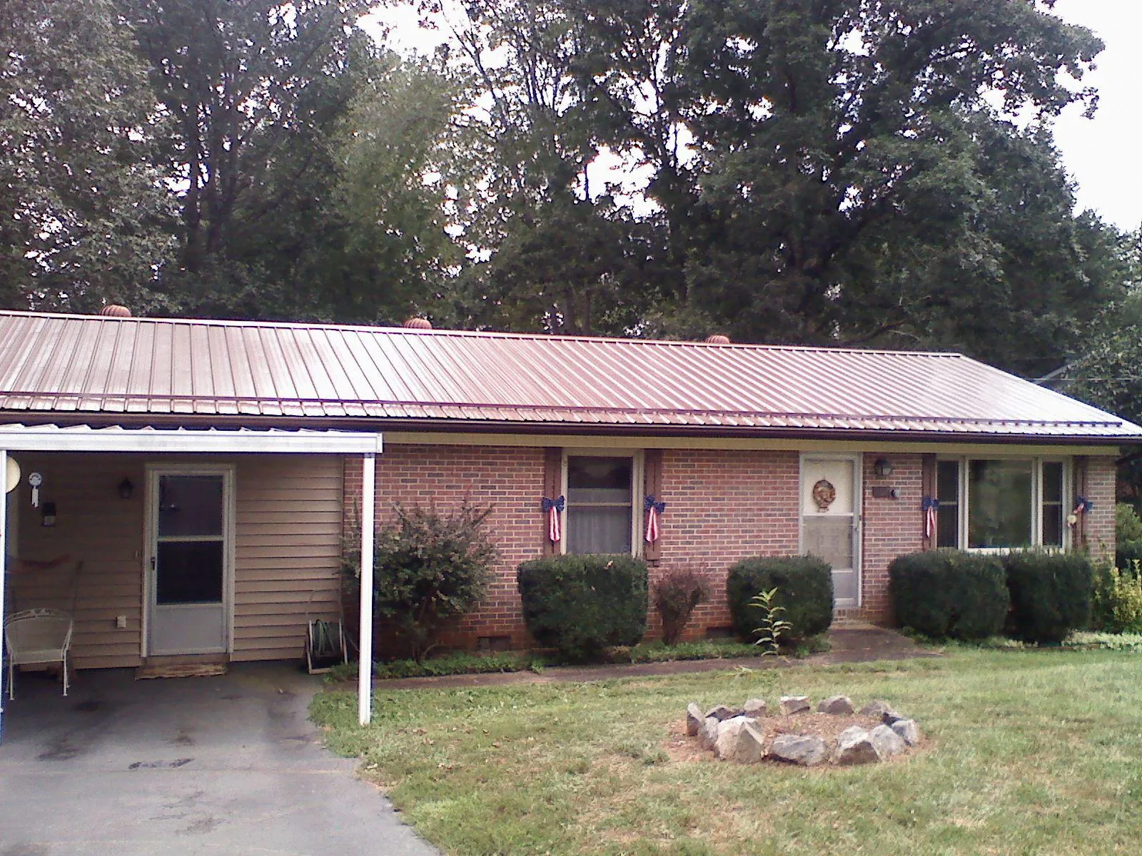 Bronze metal roof and carport on a brick ranch home — Roof Repair work by our crew in Hardwick
