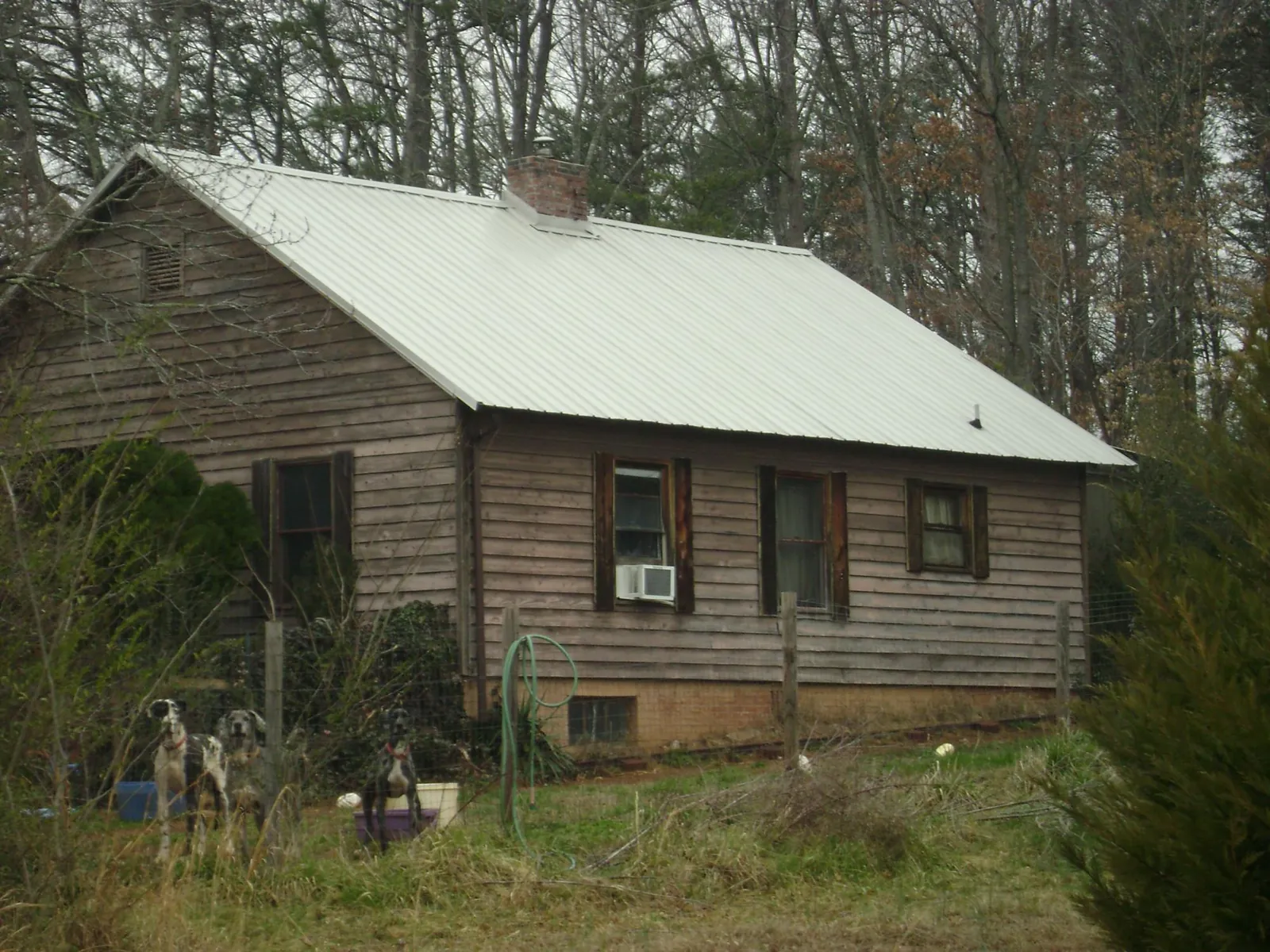 White metal roof on an old wood sided farmhouse, from a Metal Roof Installation job in Hardwick